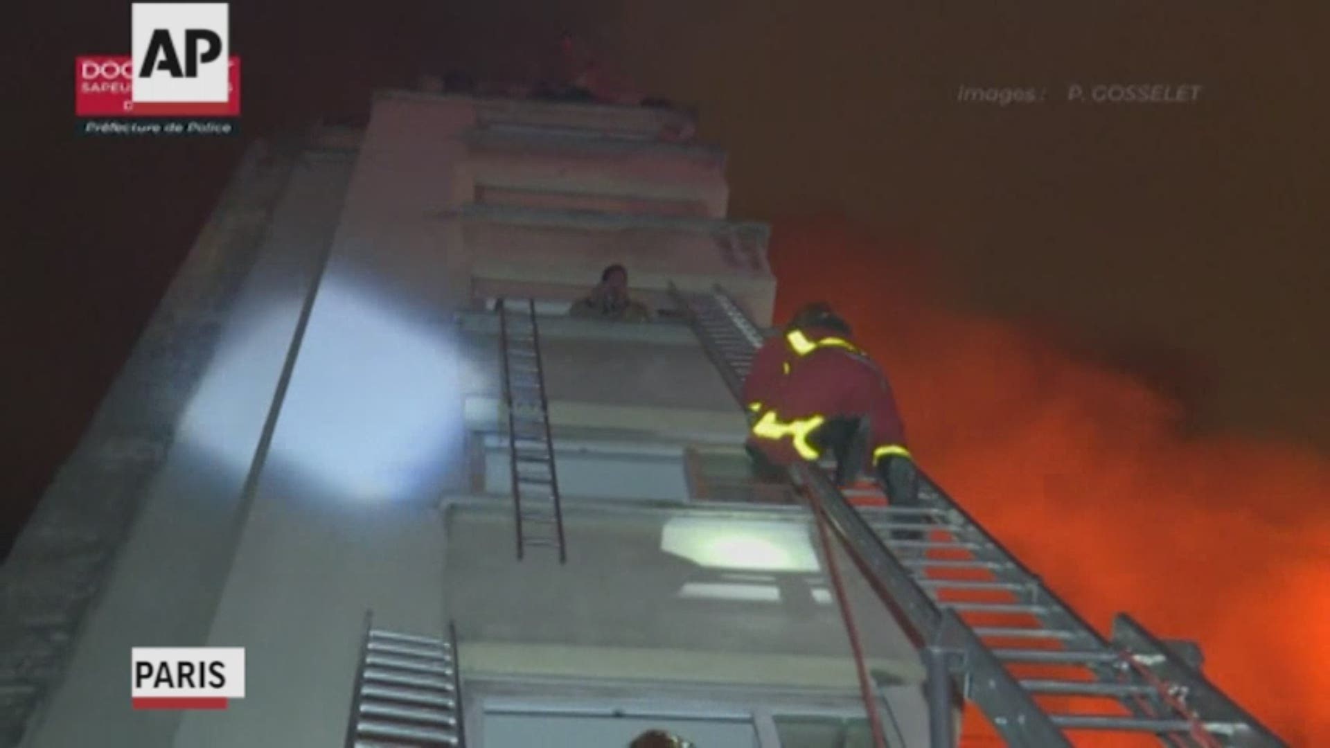 A fire in a Paris apartment building early Tuesday killed at least eight people and sent residents fleeing to the roof or climbing out of windows to escape, authorities said. (Firefighters handout video via AP)