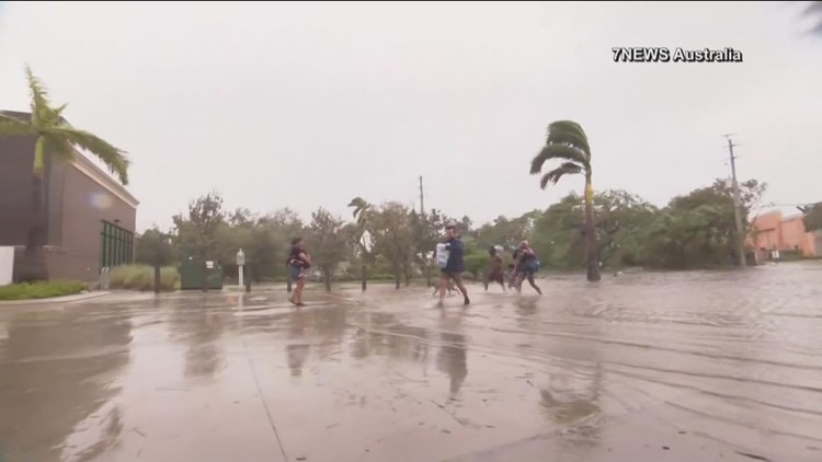 Cameraman helps families carry supplies amid Hurricane Ian