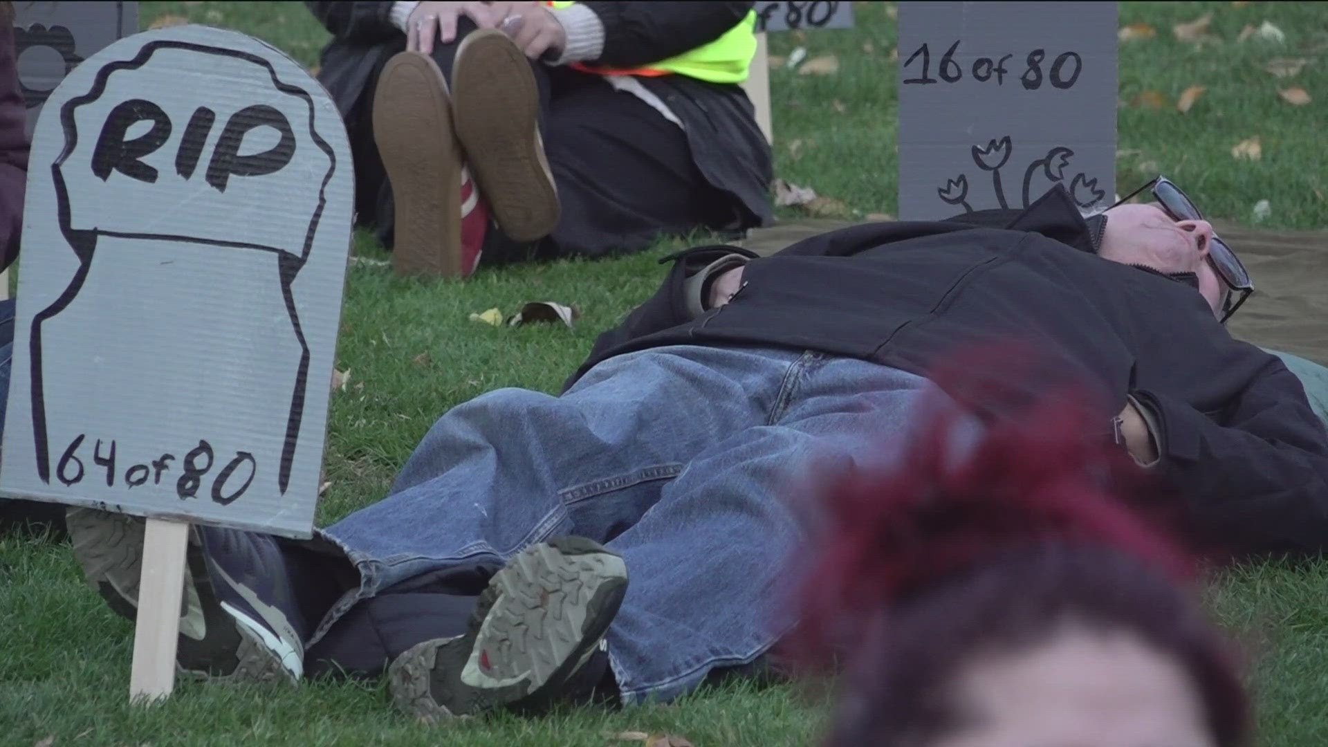 80 people lie down in Cecil Andrus Park, which organizers say will represent the lives lost amid the Affordable Care Act tax credits expiring and Medicaid cuts. 