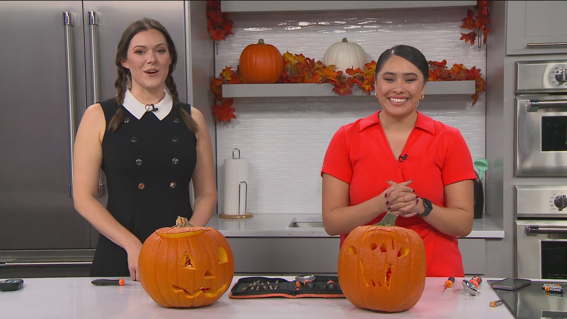 Brenda Rodriguez and Sophia Bliss carve pumpkins.