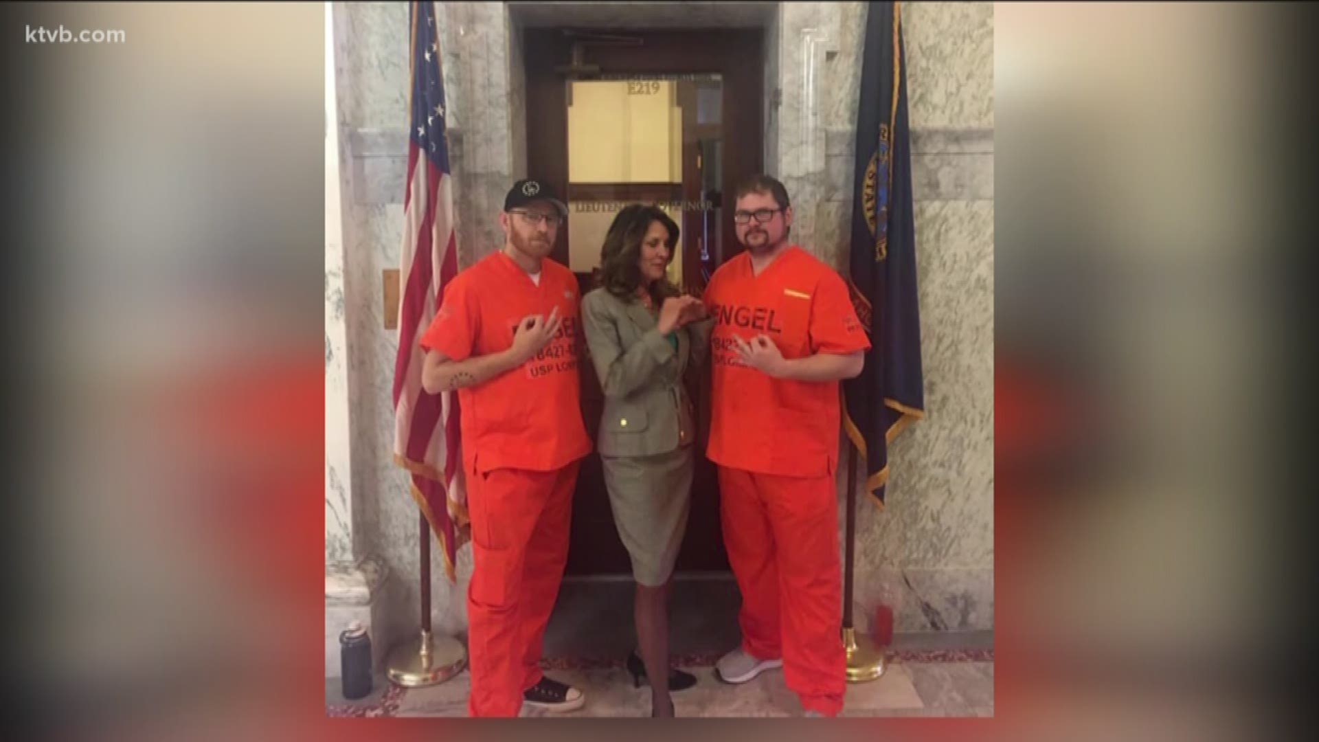 Janice McGeachin is shown posing with two men in prison garb.