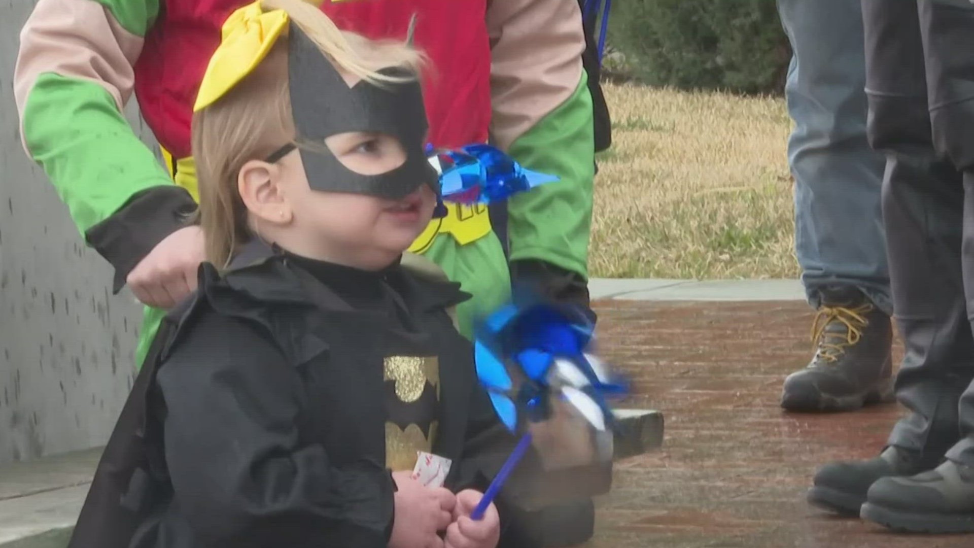 The community walked with local law enforcement in superhero outfits and blue clothing on Saturday to highlight child abuse prevention month.