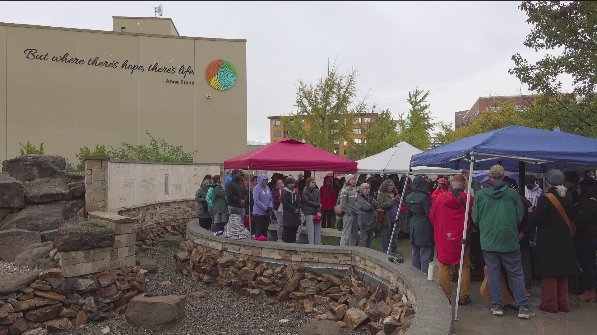 Under a steady downpour on Saturday afternoon, people gathered to demand compassion, accountability and action following a recent ICE raid.
