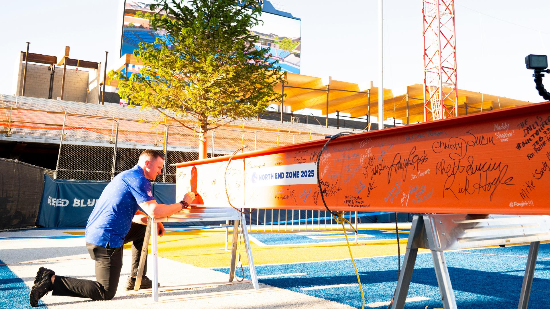 Hundreds of donors and supporters gathered Friday on The Blue as the final support beam was added to the top of an elevator shaft in Boise State's north end zone.